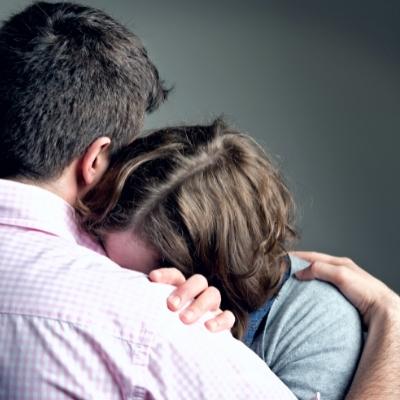 Woman crying on a man's shoulder