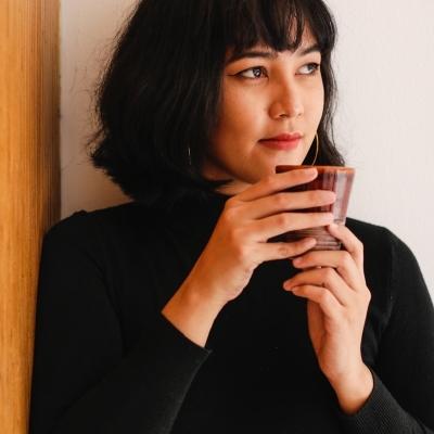 Woman drinking tea, looking pensively to the right