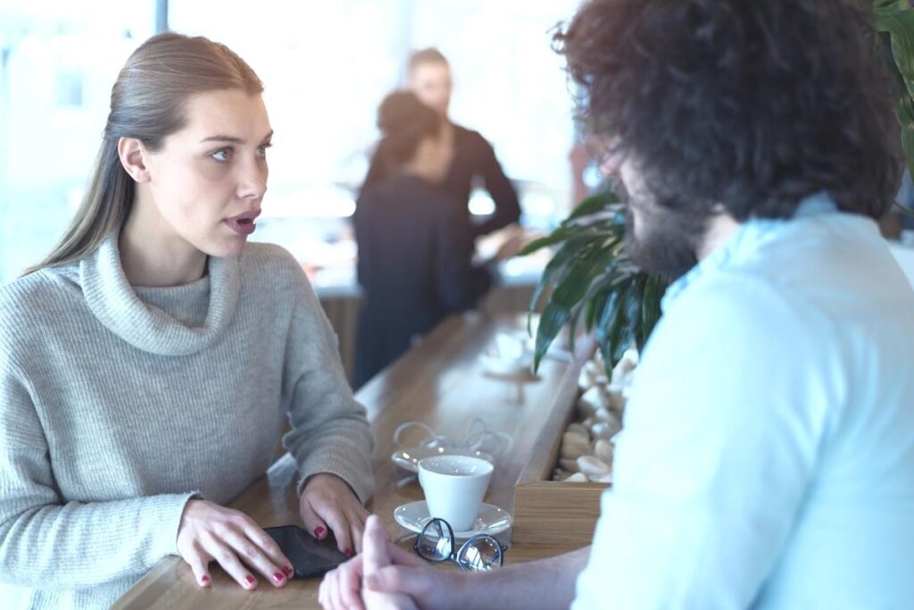 Woman in a cafe apologizing to her ex