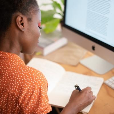 Woman journaling at her computer about her New Year's aspiration to get to know herself better