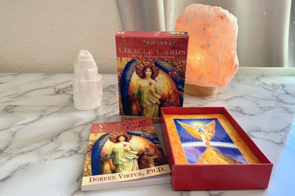 Doreen Virtue Oracle cards on desk with Himalayan salt lamp