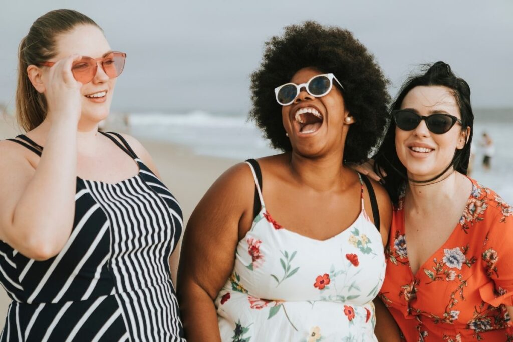 Women on the beach laughing and having fun, big personalities