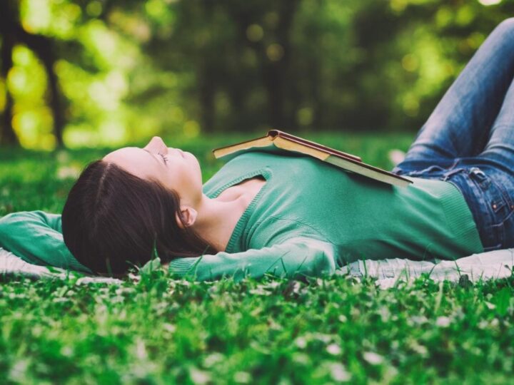 Woman relaxing in the grass saying affirmations for rest