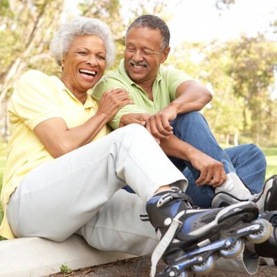 Older woman roller blading with her husband and smiling, loving life