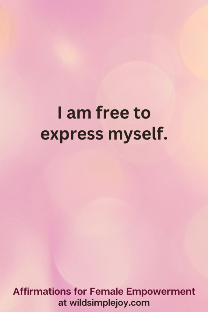Vertical pin image with pink bokeh light background and text overlay, I am free to express myself. Affirmations for Female Empowerment at wildsimplejoy.com