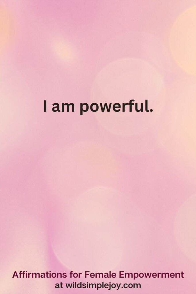 Vertical pin image with pink bokeh light background and text overlay, I am powerful. Affirmations for Female Empowerment at wildsimplejoy.com