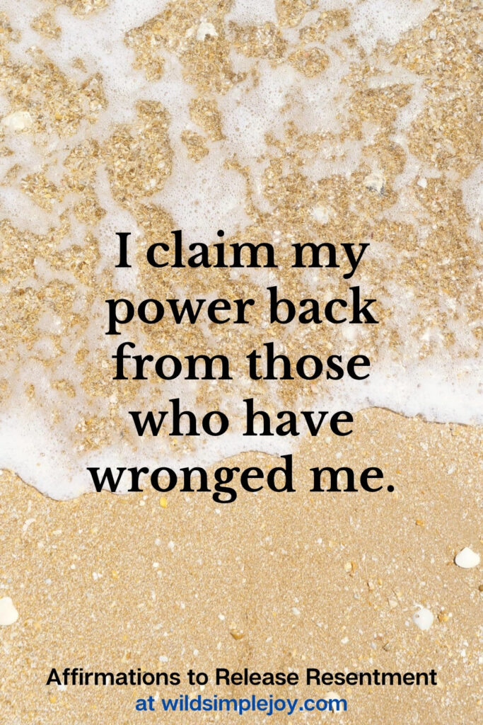 Vertical Pinterest Image with sand background and text overlay that reads I claim my power back from those who have wronged me Affirmations to release resentment at wildsimplejoy.com