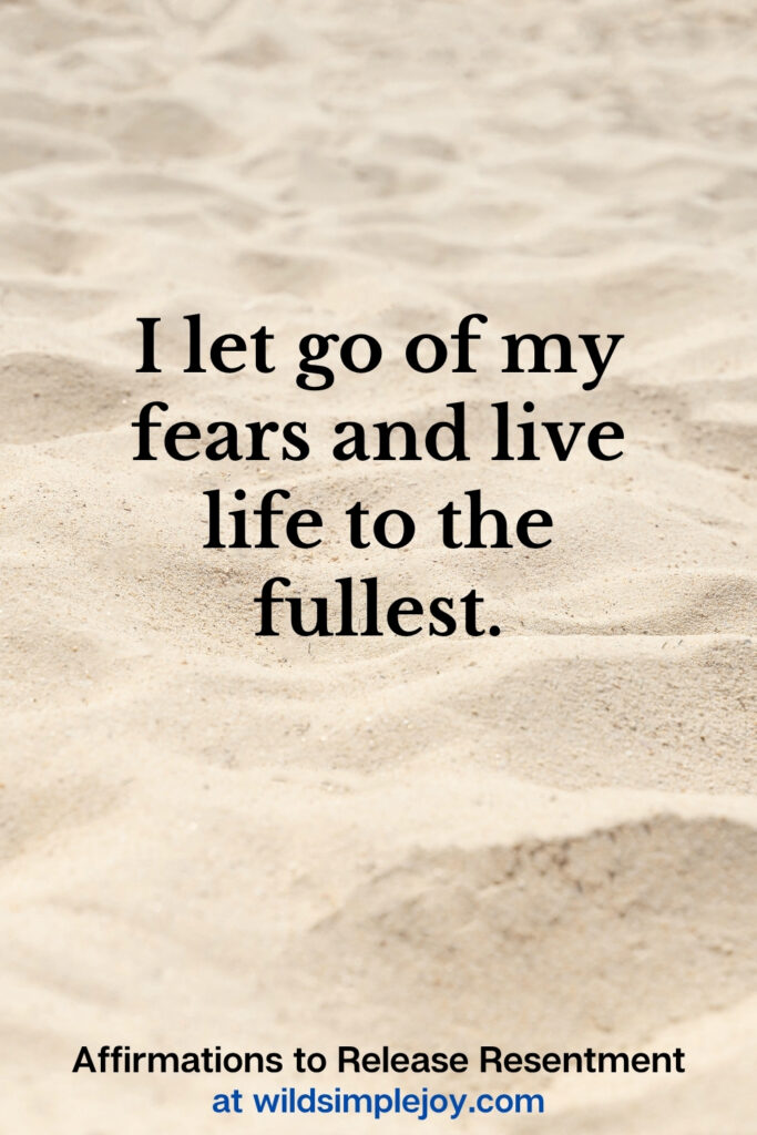 Vertical Pinterest Image with sand background and text overlay that reads I let go of my fears and live life to the fullest Affirmations to release resentment at wildsimplejoy.com