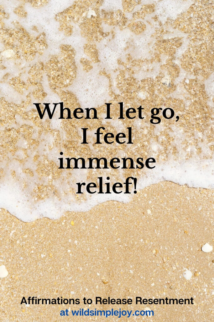 Vertical Pinterest Image with sand background and text overlay that reads When I let go, I feel immense relief Affirmations to release resentment at wildsimplejoy.com
