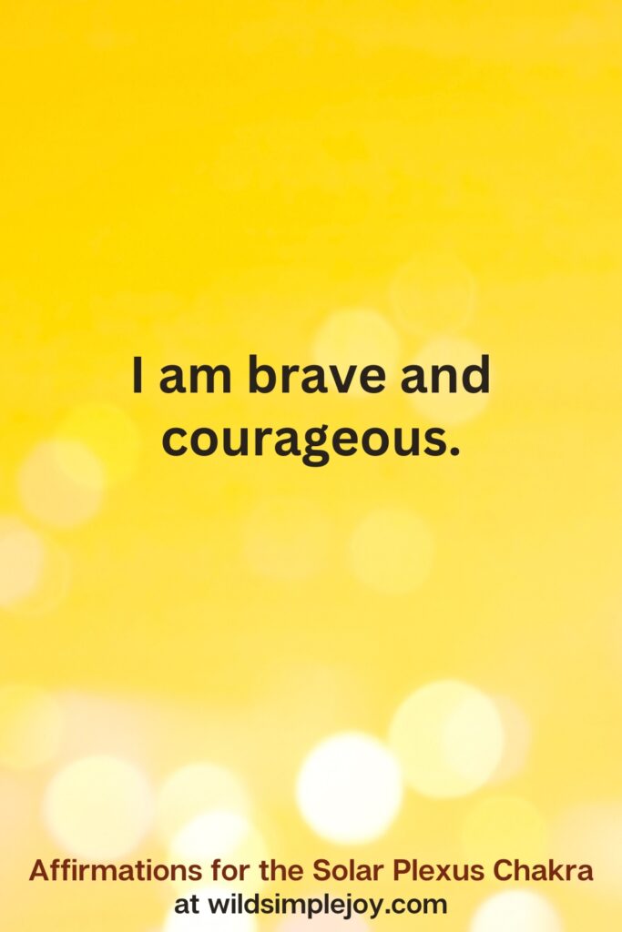 Vertical pin image with yellow background and text overlay that reads I am brave and courageous Affirmations for the Solar Plexus Chakra at wildsimplejoy.com