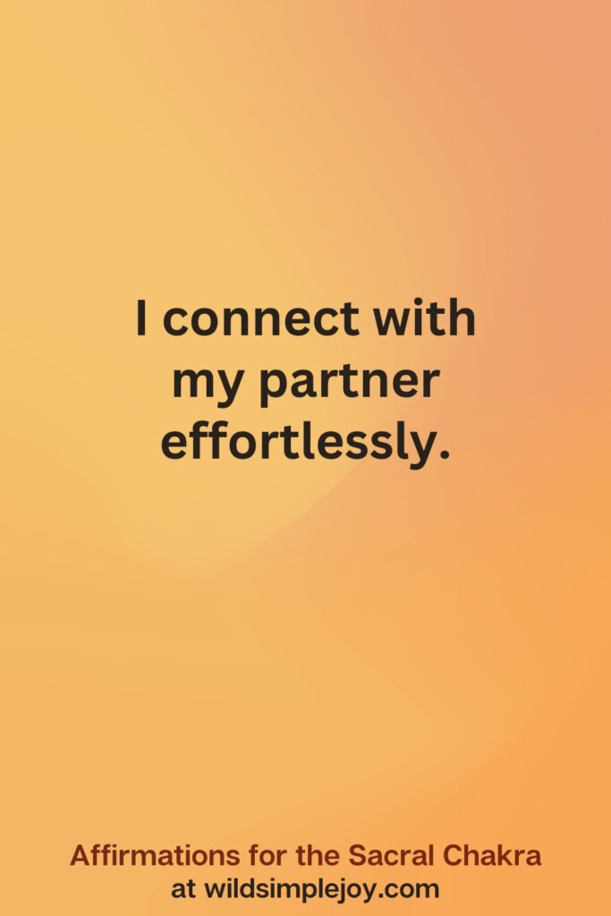 Vertical social media image on orange background with text overlay that reads I connect with my partner effortlessly. Affirmations for the Sacral Chakra at wildsimplejoy.com