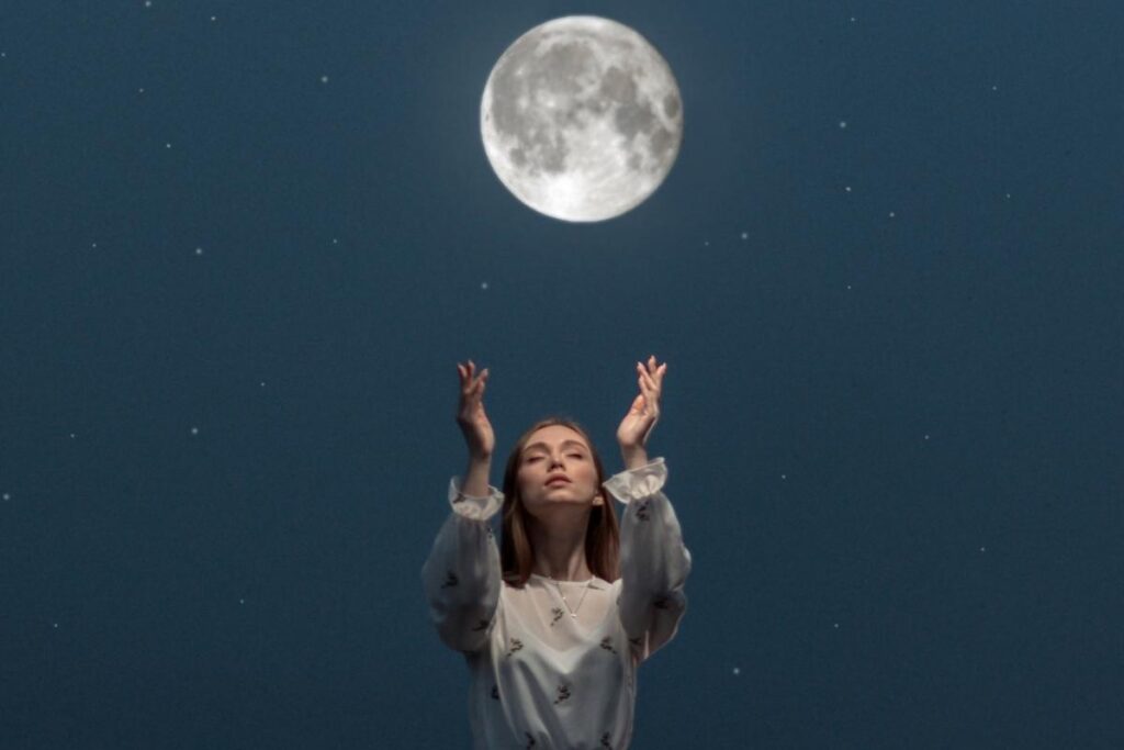 Wild woman holding hands up to the moon