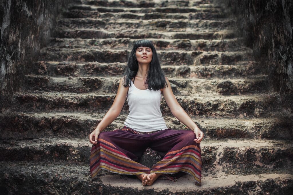 Buddhist meditating on her New Year's Resolutions on a set of stone stairs