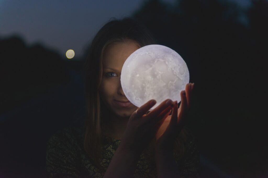 Witchy woman holding a moon in her hands