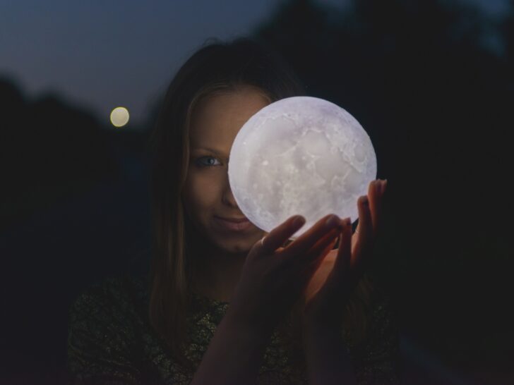 Witchy woman holding a moon in her hands