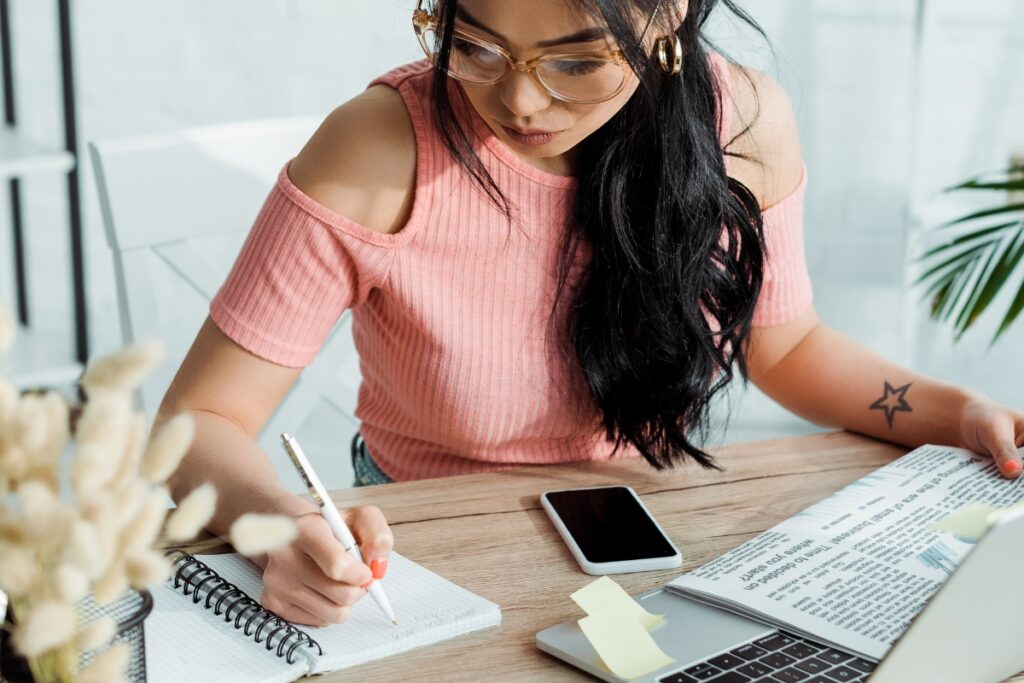 Woman writing in notebook a list of words