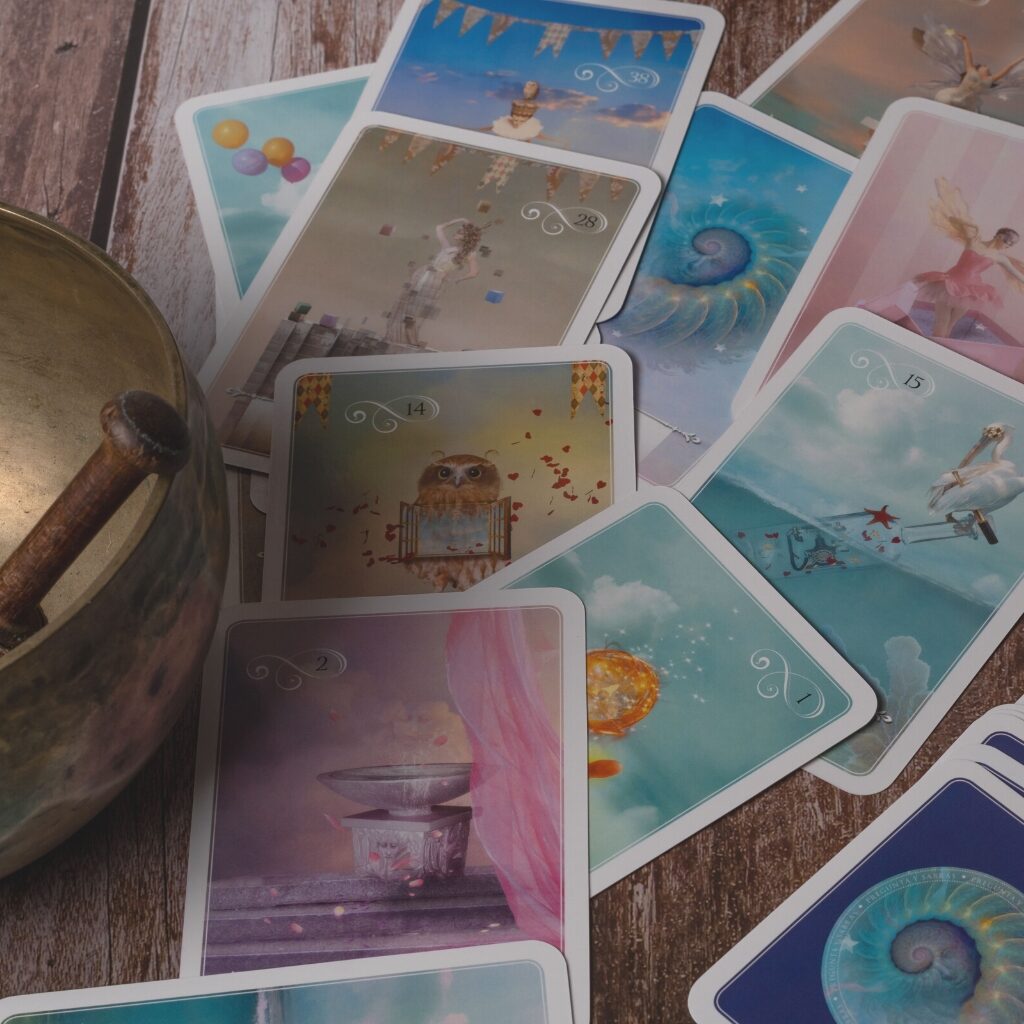 Selection of oracle cards on a table with a meditation bowl