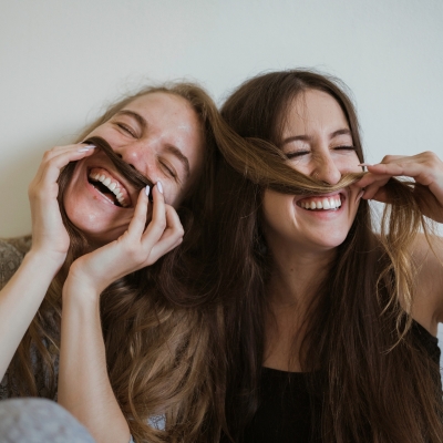 Women being silly using hair for mustaches