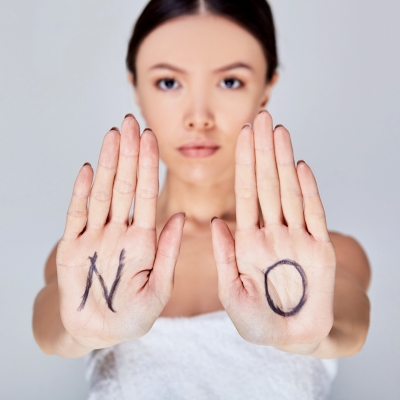 Woman with NO written on her hands