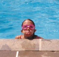 Girl sticking her tongue out at the camera from the pool.