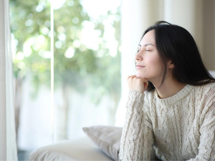Woman feeling calm sitting in front of her window