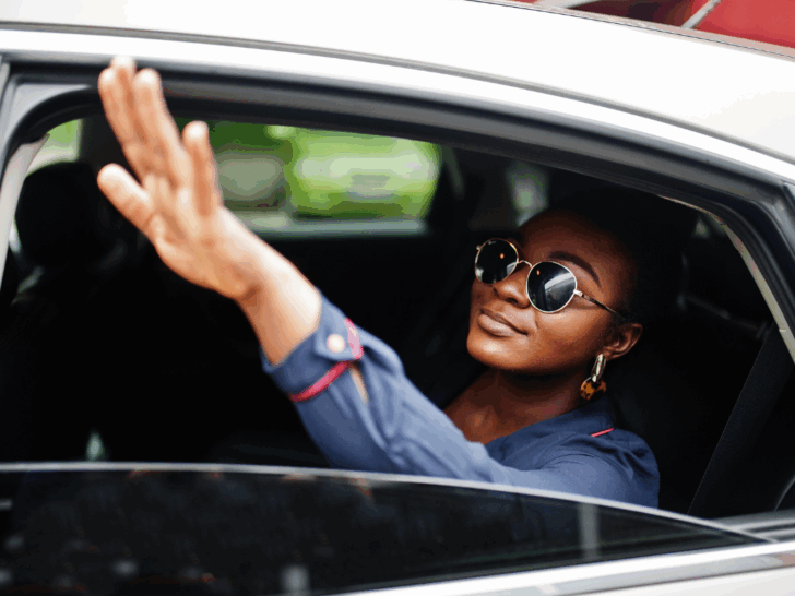 Woman in a taxi getting someone's attention with her commanding presence