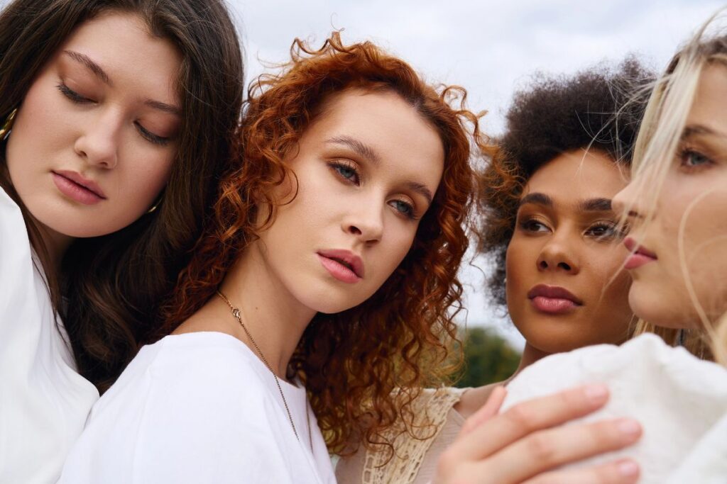 Four women wearing white standing together with serious faces
